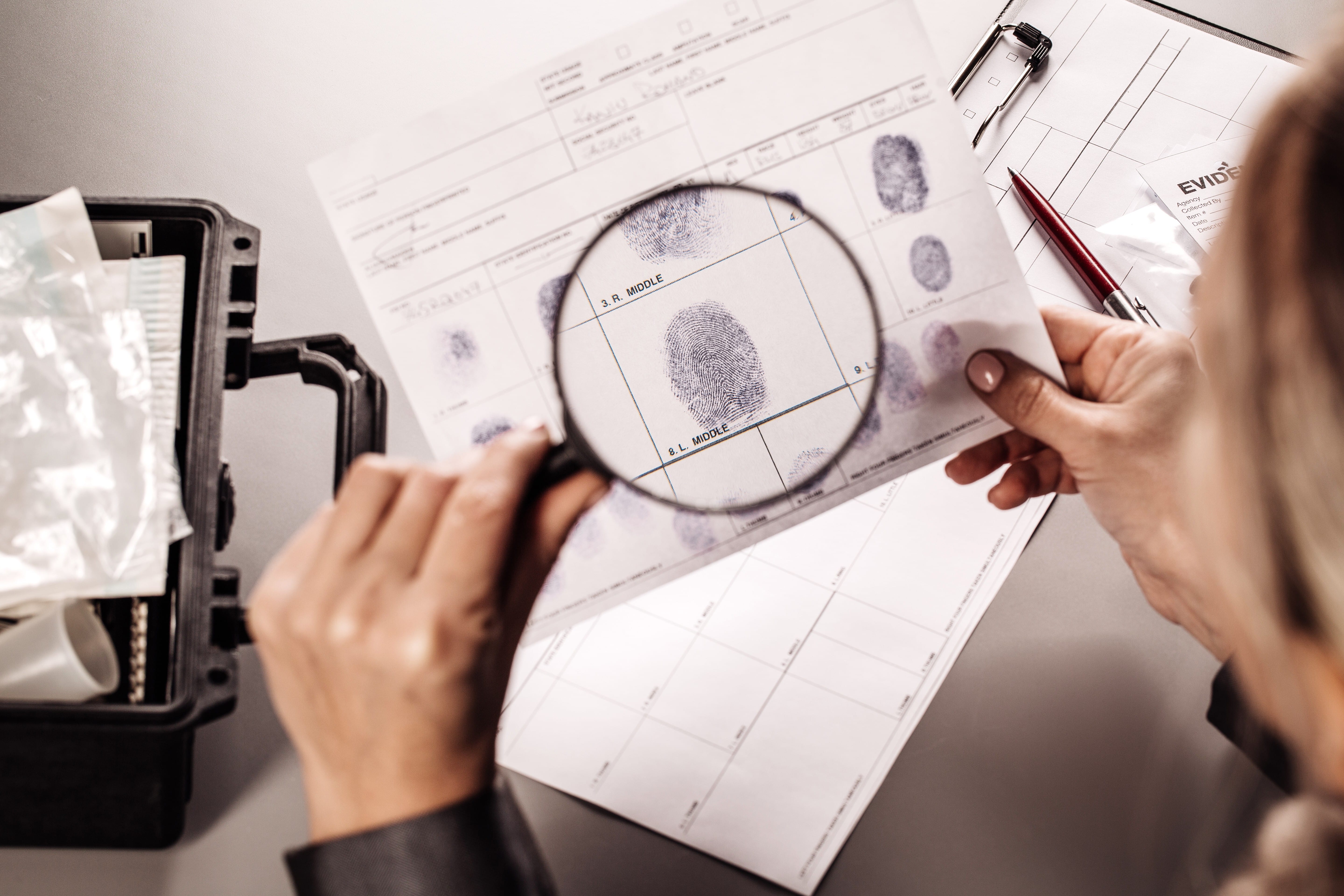 Criminology Expert Through a Magnifying Glass Looking at a Fingerprint